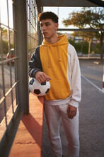Serious Man With Soccer Ball Looking Through Grid