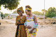 © Daniel Gonzalez/Stocksy - Black Gambian women using smartphone in village