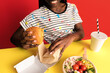 © Javier Díez/Stocksy - Smiling woman eating burger in studio