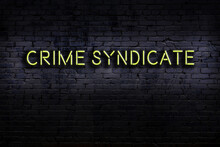 Night View Of Neon Sign On Brick Wall With Inscription Crime Syndicate