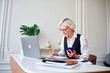 © Elena Kharichkina/Stocksy - Mature woman accountant counts taxes,