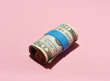 © Jeff Wasserman/Stocksy - Roll of $20 USA Bills on Pink Background