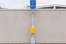 Yellow Call Box With A Blue Sign
