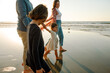 © Erin Brant/Stocksy - Young family walking on beach at sunset