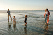 © Erin Brant/Stocksy - Young sisters in dresses playing in the ocean