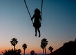 © Erin Brant/Stocksy - Silhouette of child on swing at sunset