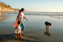 Mom And Daughters On Beach At Sunset