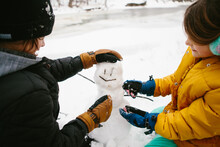 Kids Make A Little Snowman In The Forest In Winter