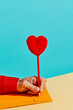 © Juan Moyano/Stocksy - man about to write with a pen topped with a plush heart