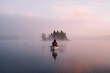 © Justin Mullet/Stocksy - Man in canoe at sunrise