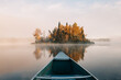© Justin Mullet/Stocksy - Canoeing toward a small island