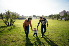 Family With Son Walking On Lawn