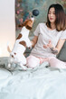 © Studio Marmellata/Stocksy - Woman playing with active dog on bed
