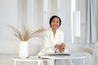 © Sergey Narevskih/Stocksy - Smiling black businesswoman in cabinet