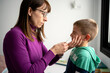 © Albert Martinez/Stocksy - Mother doing unpleasant nasal test to boy