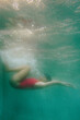 © Duet Postscriptum/Stocksy - Woman in a red sports swimsuit swims in the pool