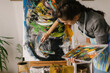 © STUDIO TAURUS/Stocksy - Female art student painting on canvas in home studio