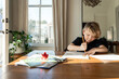 © Ali Harper/Stocksy - Little boy doing homework at dining room table