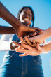 © Manu Padilla/Stocksy - Group of diverse people stacking hands