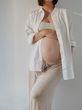 Pregnant Woman Against White Wall.