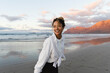 © Michela Ravasio/Stocksy - Smiling girl enjoying the beach at sunset