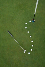 Putting Green With Line Of Golf Balls And Putter