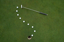 Golf Putter And Balls At The Hole