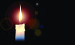 White candle in dark black background on halo sparkling for meditation