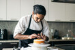 © Pedro Merino/Stocksy - pastry chef assembling a cake