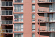 © Shava Cueva/Stocksy - Pink wooden building with glass windows and balconies