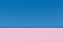 Pink Brick Wall With Blue Sky In The Background