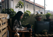 Young Woman With Laptop In A Living Room