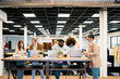 © Santi Nuñez/Stocksy - Multiracial colleagues coworking at table with laptops