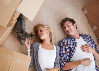 Poster - Catching a break while moving house. Shot of a couple lying on the floor happily after a long day of moving house.