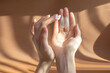Beautiful women's palms apply cream, lotion to skin. Fingers rub white oily liquid into hands. Concept of care and beauty