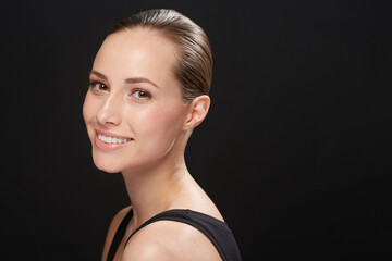 Sticker - Brunette Beauty. Cropped view of a naturally beautiful young brunette smiling against a black background.