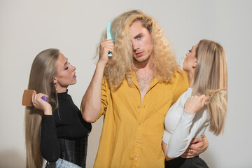 Diverse group of women and man combing hair isolated over background. Attractive cheerful sexy, fashionable group models combing hair. Group portrait of young people combing hair.