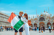 smiling couple holding italian flag venice central square san marco