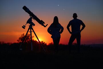 Wall Mural - Couple stargazing together with a astronomical telescope.