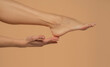 © vladimirfloyd - Foot Heel Skin Care, Woman Touch Healthy Feet Body by Hand, Leg over Beige Background