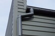 long black plastic drain pipe on the iron wall of the building on the street