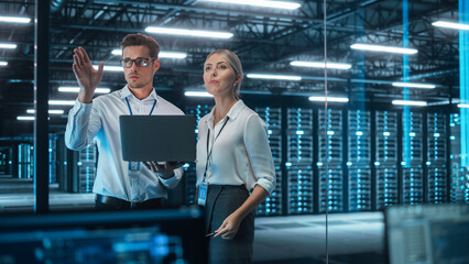 In Technology Research Facility: Female Project Manager Talks With Chief Engineer, they Consults with Each Other. Team of Industrial Engineers, Developers Work on Engine Design Using Computer