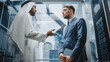 © Gorodenkoff - Businessman Talking with Arab Investment Partner while Riding Glass Elevator to Office in a Modern Business Center. International Corporate Associates Discussing Details of a Deal in a Lift.