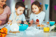 © Dragana Gordic - Happy young family decorating Easter eggs. Happy family spending time together during Easter holiday at home.  Two cute kids painting easter eggs with mom and dad.