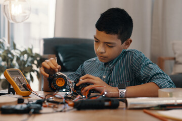 Wall Mural - Hes a boy on a mission. Shot of a handsome young boy building a robotic toy car at home.