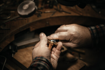 Different goldsmiths tools on the jewelry workplace. Jeweler at work in jewelry. Desktop for craft jewelry making with professional tools. Close up view of tools.