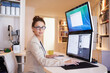 © Mariusz S/peopleimages.com - My dual-screen gives me increased productivity. Portrait of a young woman working on a dual-screen computer at home.
