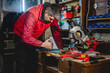 © Miljan Živković - One man caucasian adult male working by the circular saw and work tools at garage workshop real people copy space hobby and craft concept