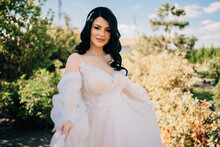 Brunette Bride In A Dress With A Bouquet Of Flowers Outdoors 