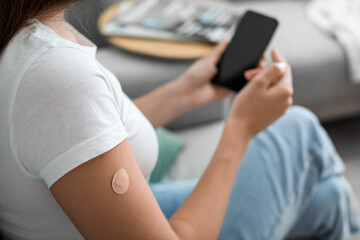 young woman with applied nicotine patch using mobile phone at home. smoking cessation